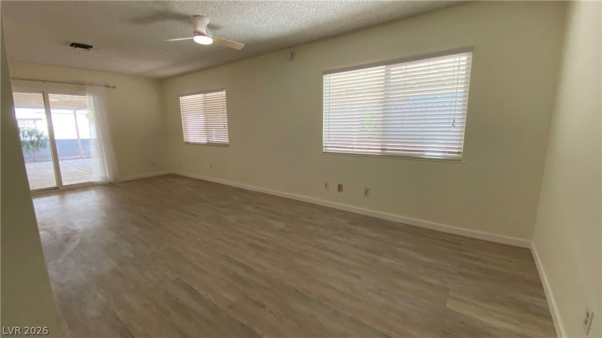 Las Vegas, NV 89119 Smooth wood flooring and sliding glass doors highlight this versatile living area.