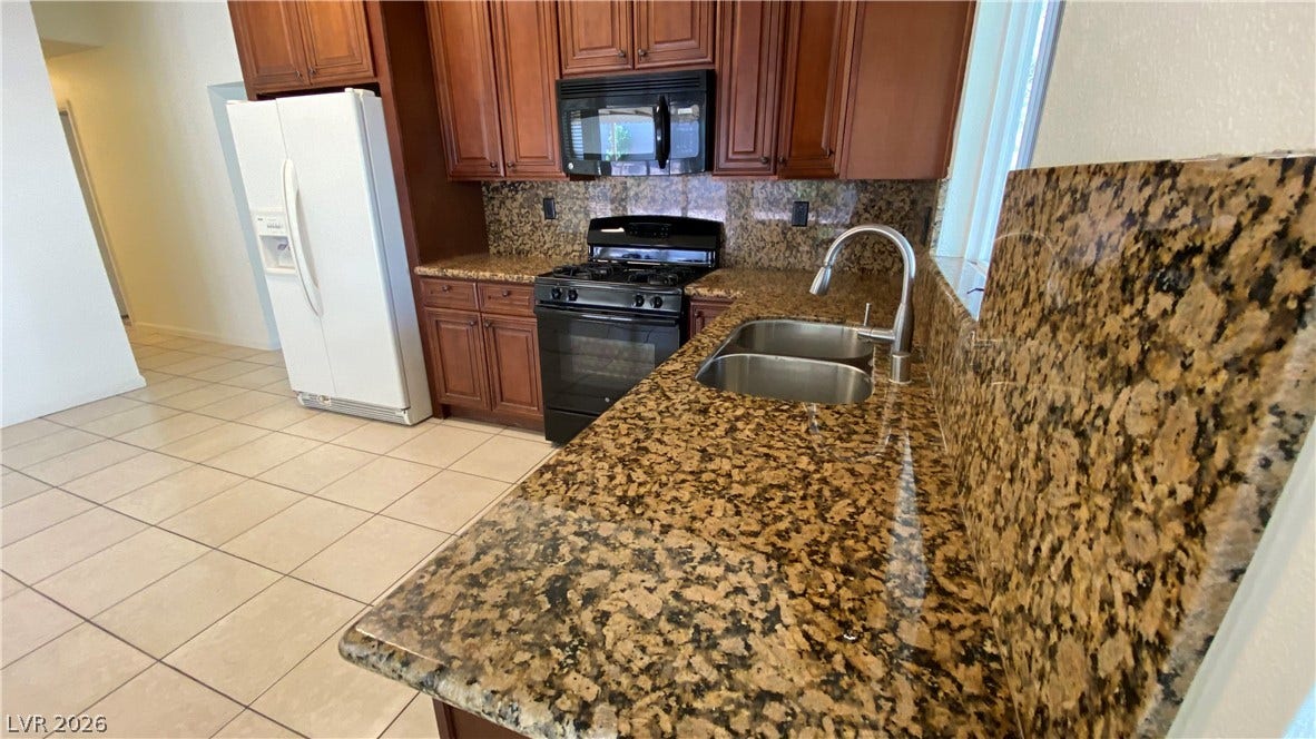 Las Vegas, NV 89119 Rich wood cabinetry and polished granite countertops define this functional kitchen space.