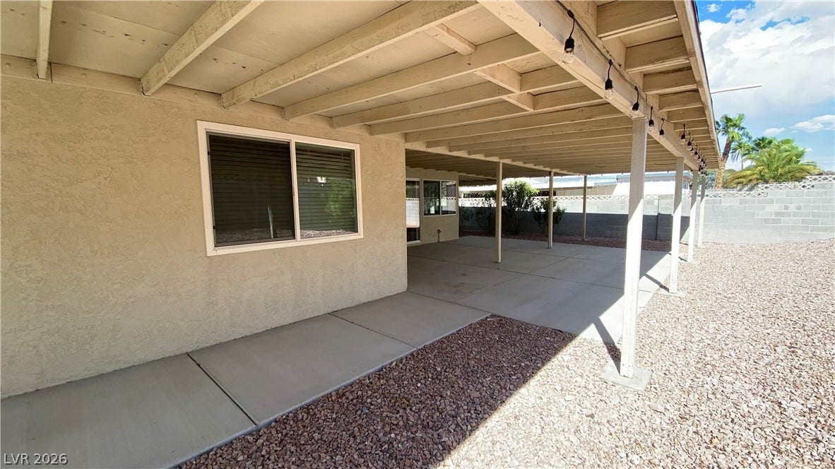 Las Vegas, NV 89119 An expansive covered concrete patio runs along the stucco exterior of this desert home.