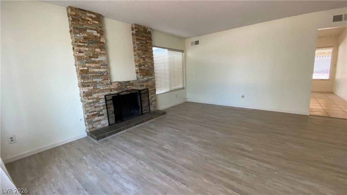 Las Vegas, NV 89119 An inviting stone fireplace anchors the spacious main living area featuring wood-look flooring.