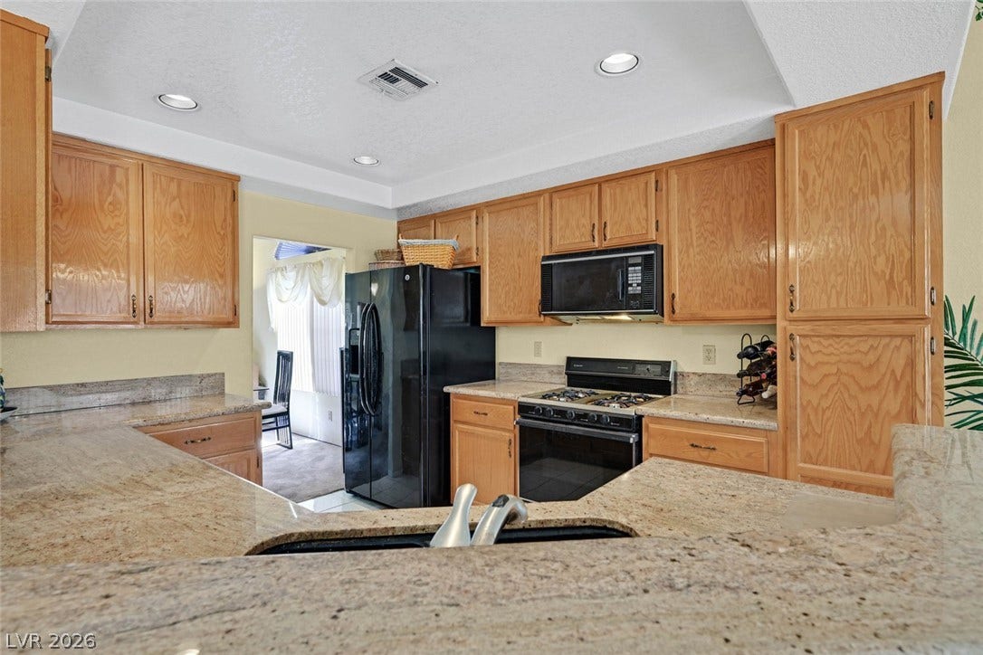 805 Stillwater Lane, Henderson, NV 89014 Ample wooden cabinetry and granite countertops define this functional kitchen space.