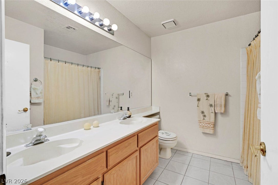 805 Stillwater Lane, Henderson, NV 89014 Tiled flooring and a long double vanity define this functional bathroom space.