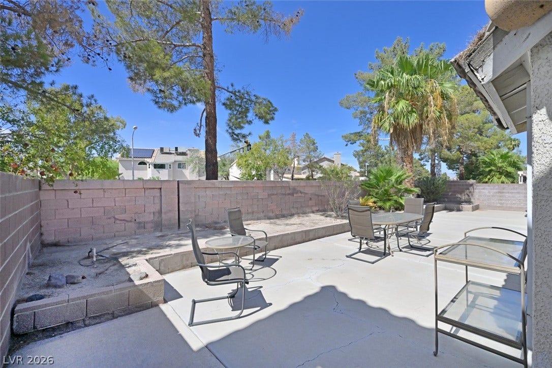 805 Stillwater Lane, Henderson, NV 89014 A spacious concrete patio is enclosed by a privacy block wall and lined with planting beds.