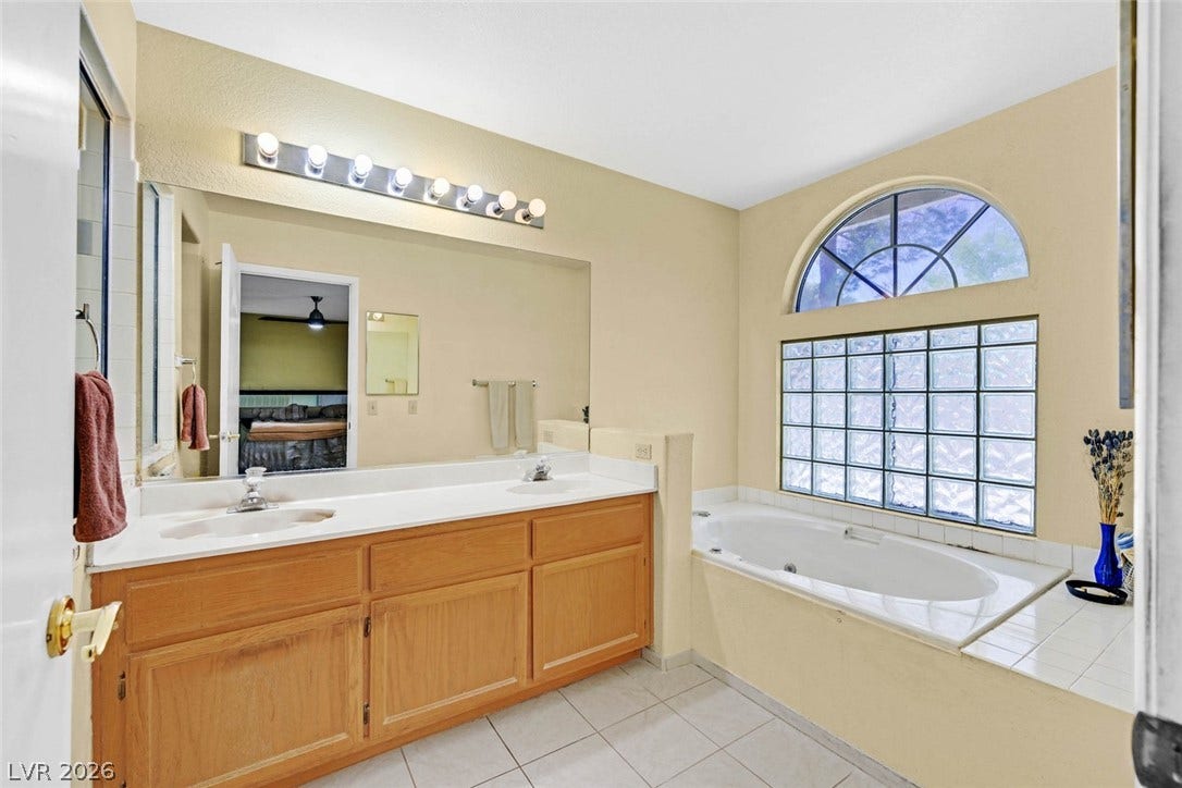 805 Stillwater Lane, Henderson, NV 89014 Tiled flooring and a deep soaking tub anchor this spacious primary bathroom.