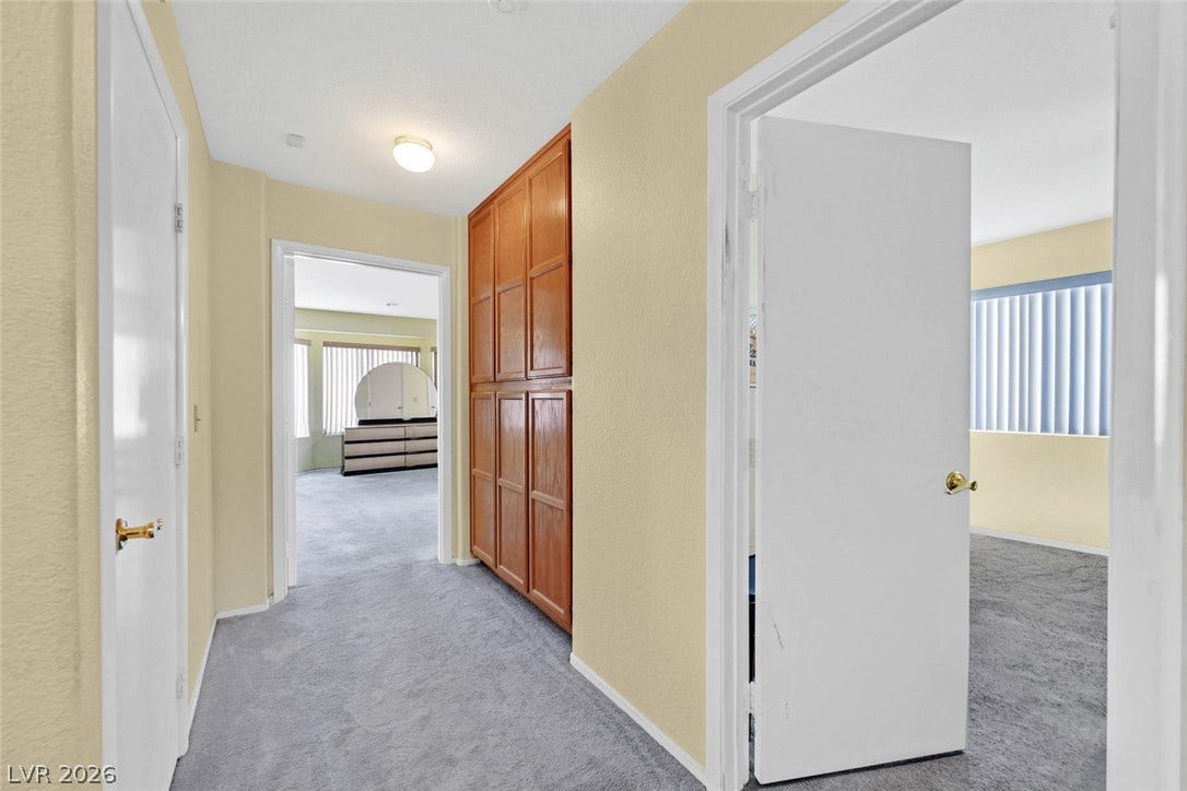 805 Stillwater Lane, Henderson, NV 89014 Rich wood built-in cabinetry provides abundant storage along this carpeted hallway.