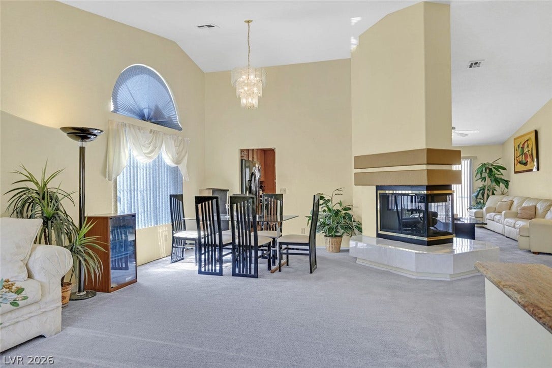 805 Stillwater Lane, Henderson, NV 89014 A double-sided fireplace on a raised tile hearth commands this open dining area.