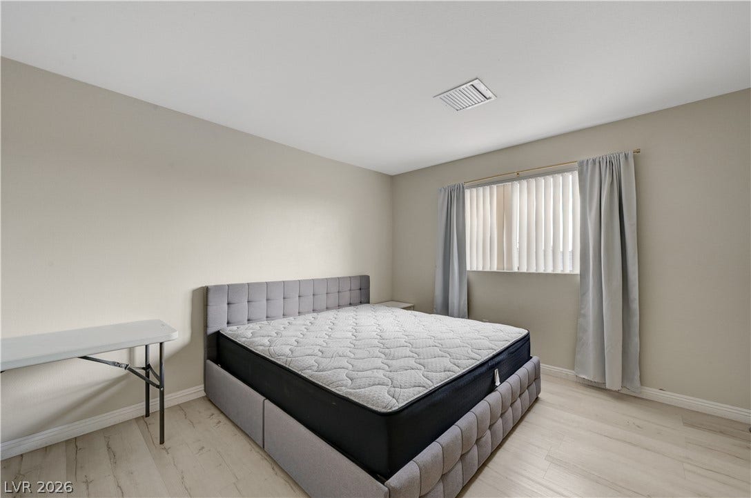 2025 Hollow Oak Avenue, North Las Vegas, NV 89031 Smooth wood floors and tall ceilings create a clean backdrop for this comfortable bedroom.