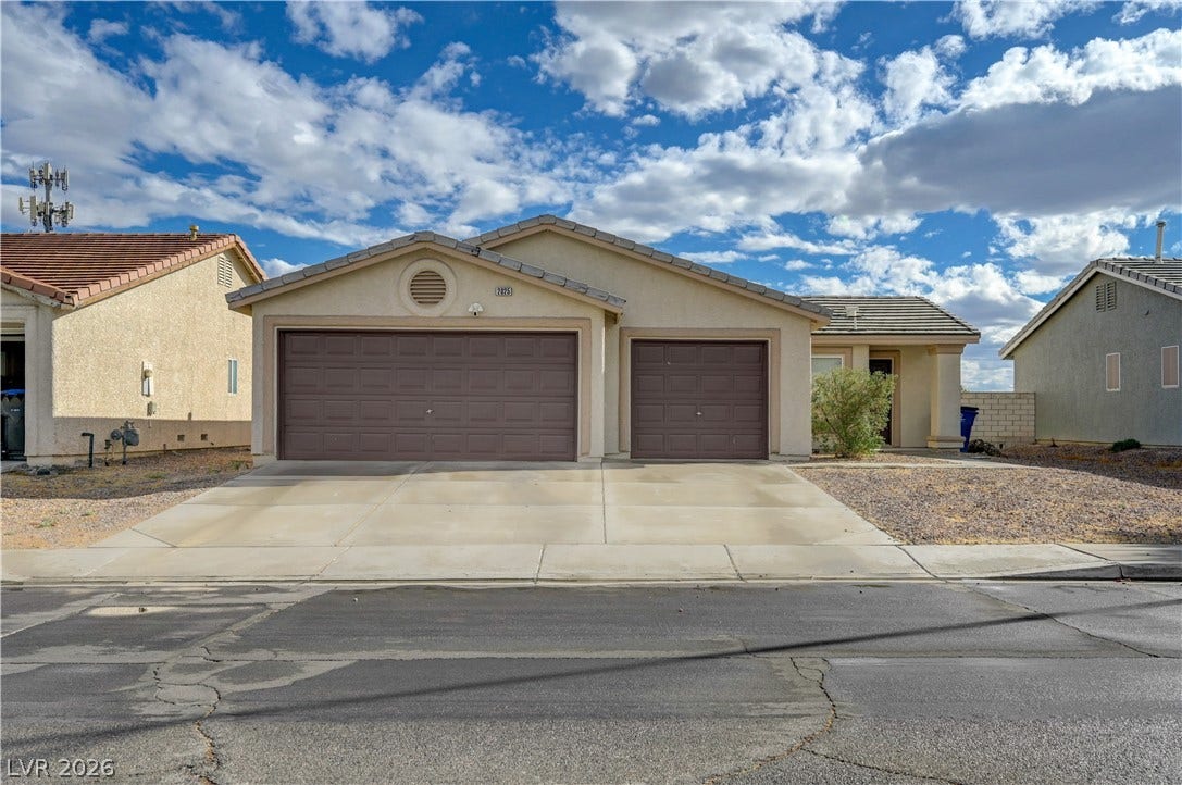2025 Hollow Oak Avenue, North Las Vegas, NV 89031 Stucco exterior and concrete driveway enhance the curb appeal of this ranch-style home.