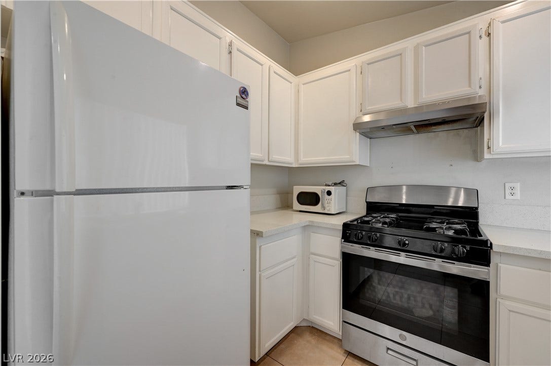 2025 Hollow Oak Avenue, North Las Vegas, NV 89031 Functional cabinetry pairs with resilient stone counters in this well-arranged cooking space.