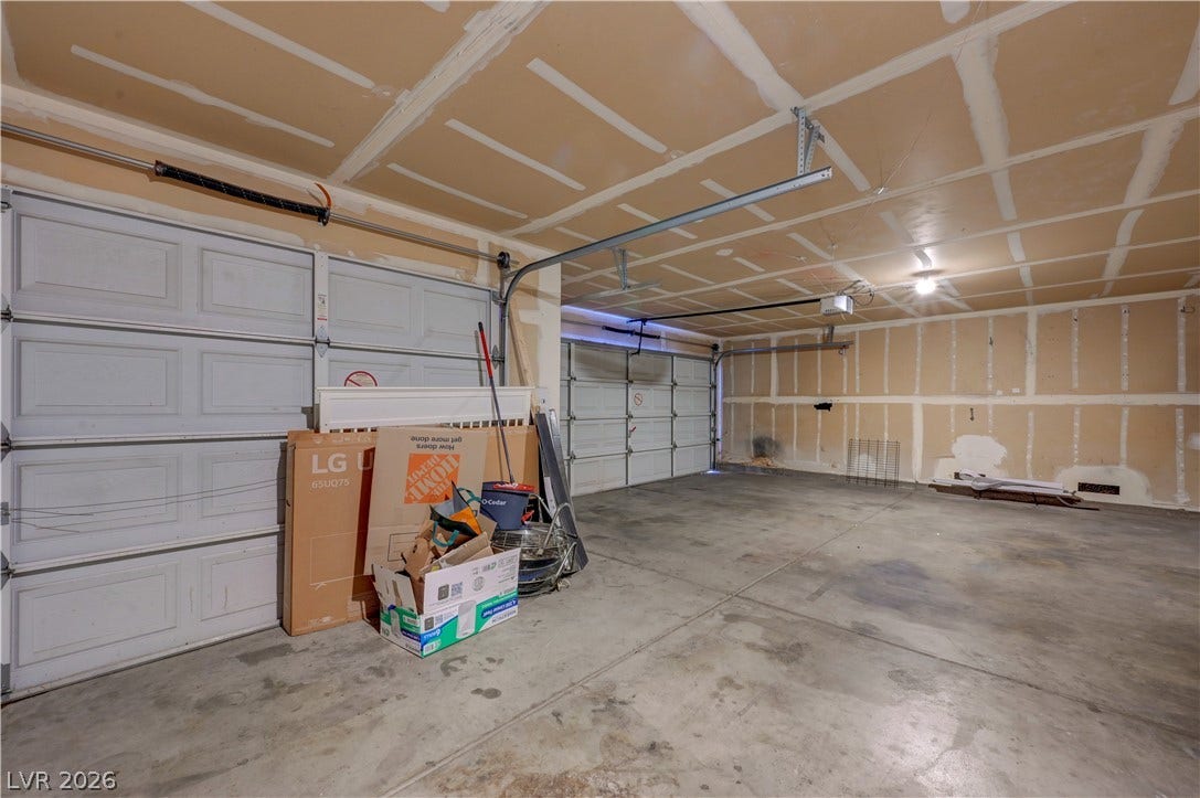2025 Hollow Oak Avenue, North Las Vegas, NV 89031 A spacious multi-car garage features solid concrete flooring and unfinished drywall walls.