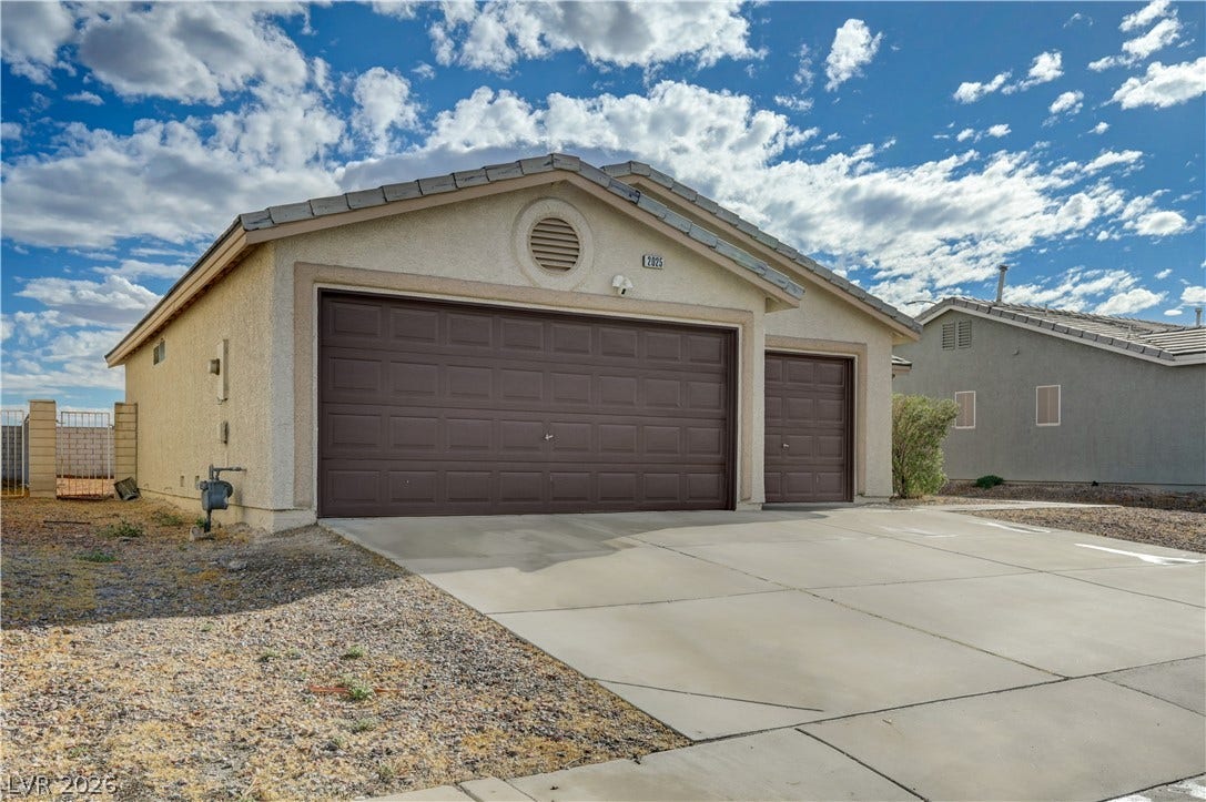 2025 Hollow Oak Avenue, North Las Vegas, NV 89031 Stucco exterior siding and a spacious concrete driveway lead to the multi-car garage.