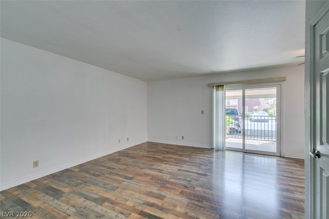 5240 Indian River Drive, #273, Las Vegas, NV 89103 Rich wood-look flooring anchors this open room featuring large sliding glass doors.