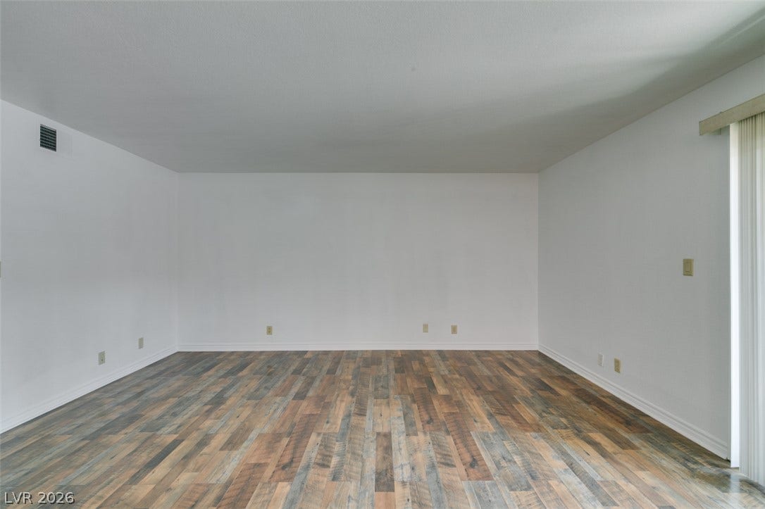 5240 Indian River Drive, #273, Las Vegas, NV 89103 Gleaming wood-look floors anchor a versatile living space equipped with sliding glass doors.