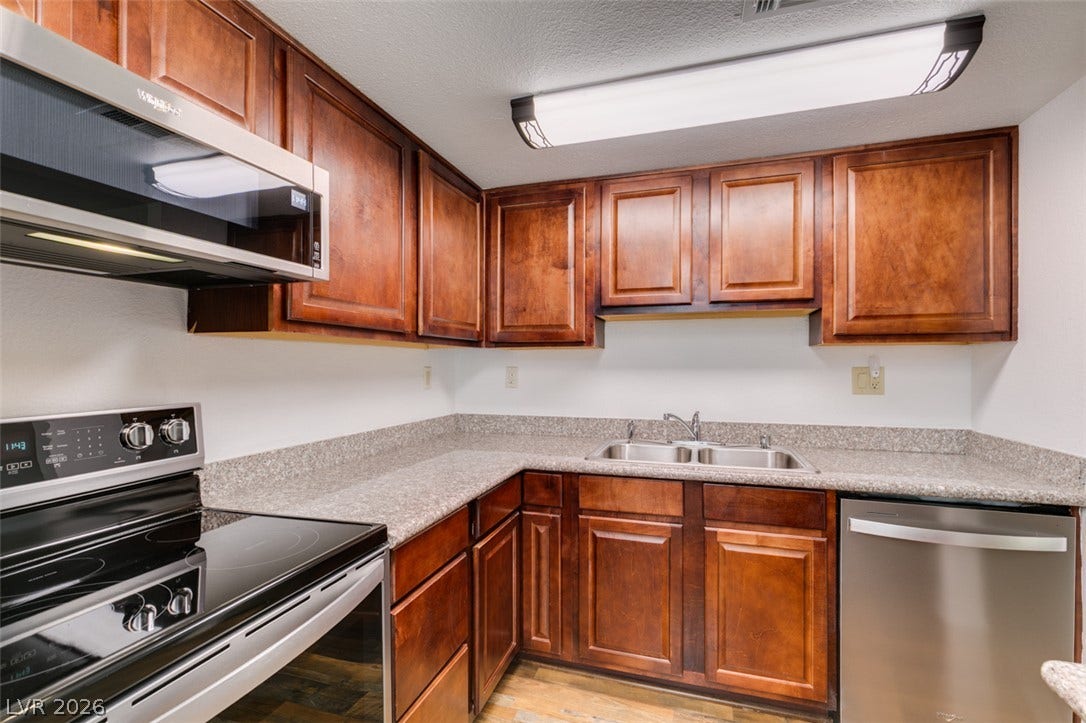 5240 Indian River Drive, #273, Las Vegas, NV 89103 Rich wood cabinetry surrounds durable stone counters in this functional cooking space.