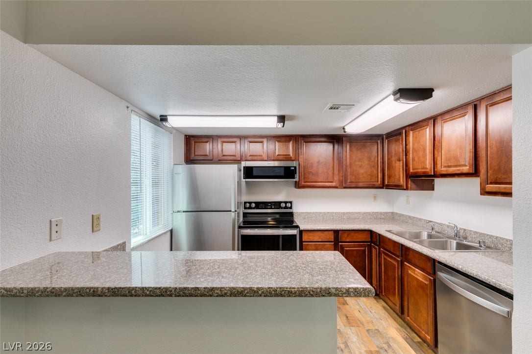 5240 Indian River Drive, #273, Las Vegas, NV 89103 Rich wood cabinetry contrasts beautifully with granite countertops in this functional workspace.