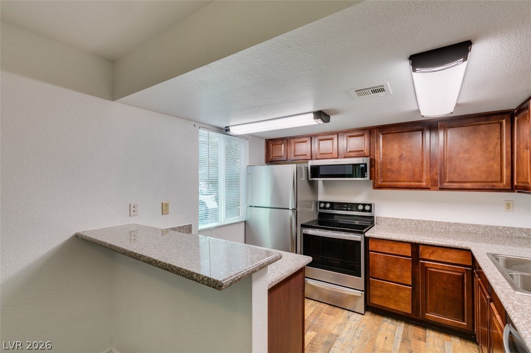 5240 Indian River Drive, #273, Las Vegas, NV 89103 Rich wood cabinetry contrasts beautifully with granite countertops in this functional workspace.
