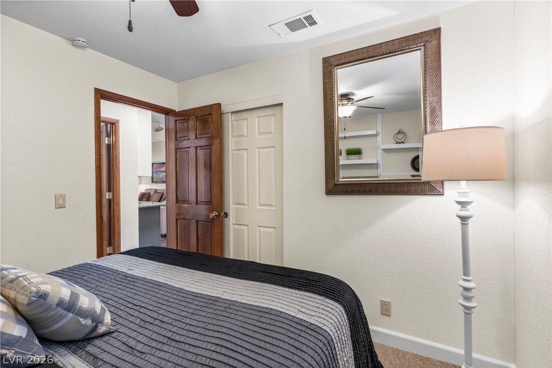 Rich wood trim frames the entryways in this cozy bedroom space.