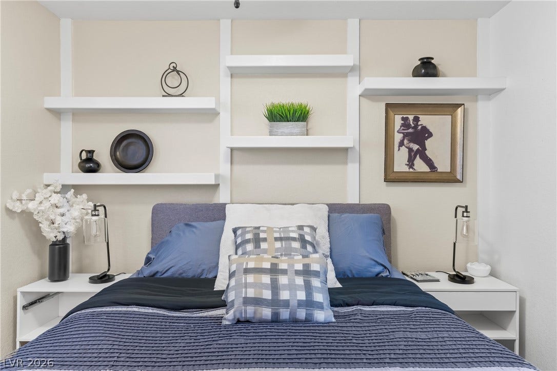 Custom built-in shelving spans the wall above the bed, maximizing vertical storage space.