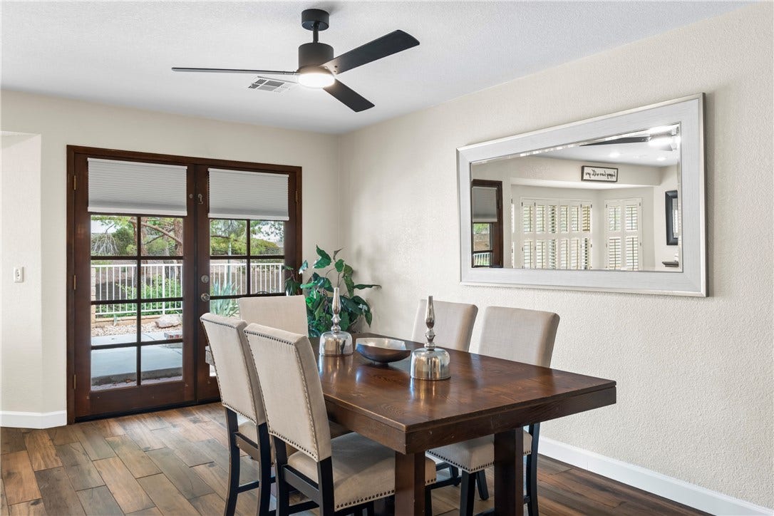 Multi-pane French doors open to the outdoor patio from this inviting dining space.