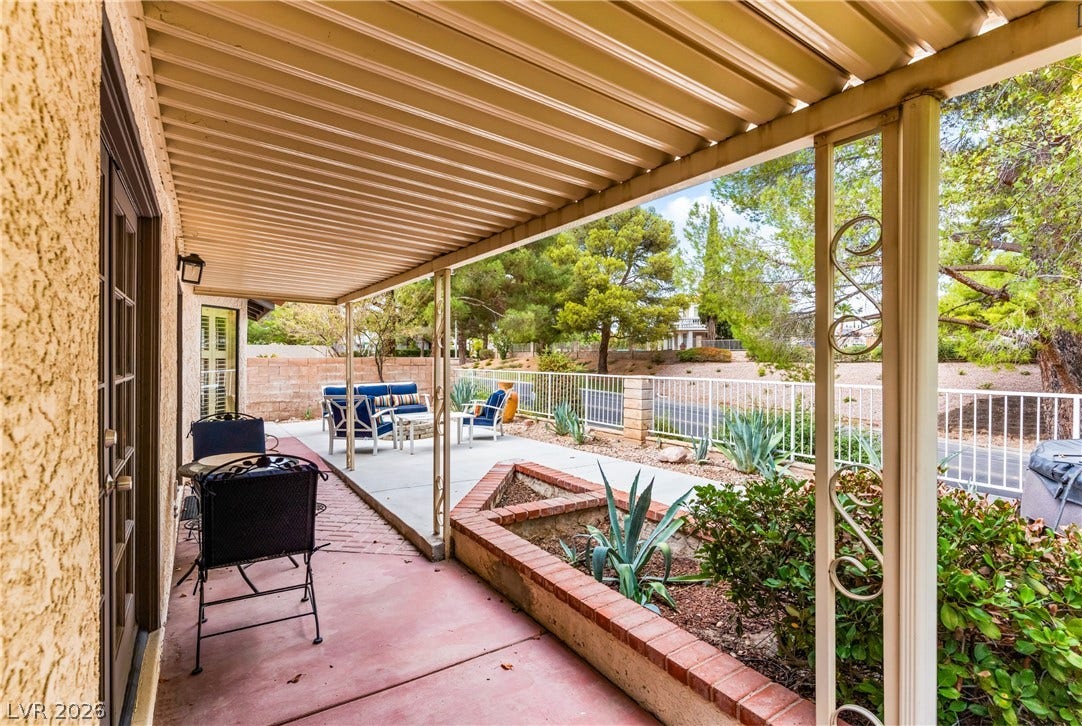 Shaded outdoor spaces connect seamlessly with the surrounding landscape through classic French doors.