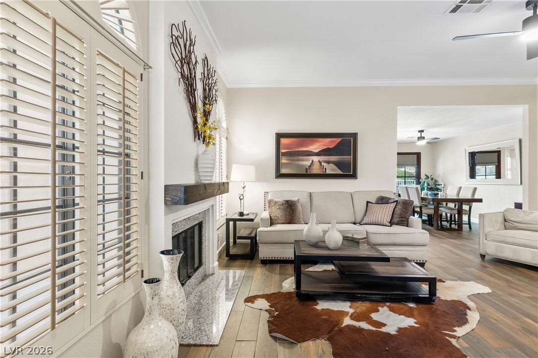 Hardwood floors and a cozy fireplace define this elegant open-concept living space.