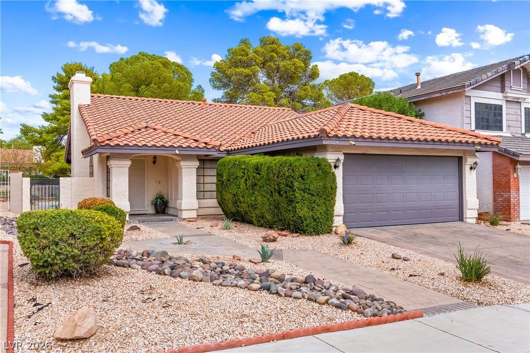Spanish tile roofing and desert-friendly landscaping create classic Southwestern curb appeal.