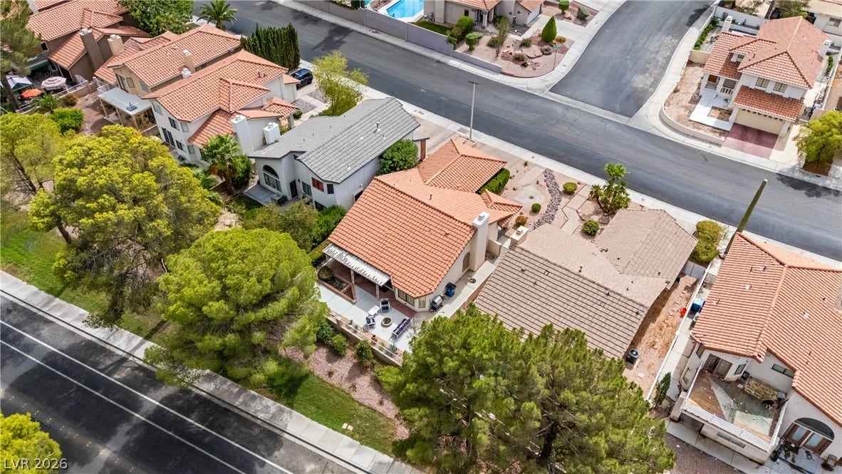 An aerial perspective shows the classic tile roofs and neat landscaping of the neighborhood.