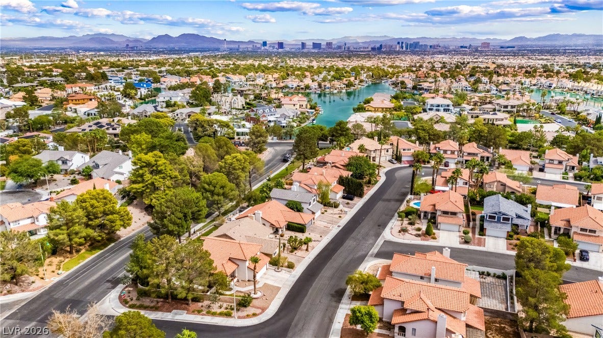 An aerial perspective showcases the surrounding neighborhood, featuring nearby waterways and distant skyline views.