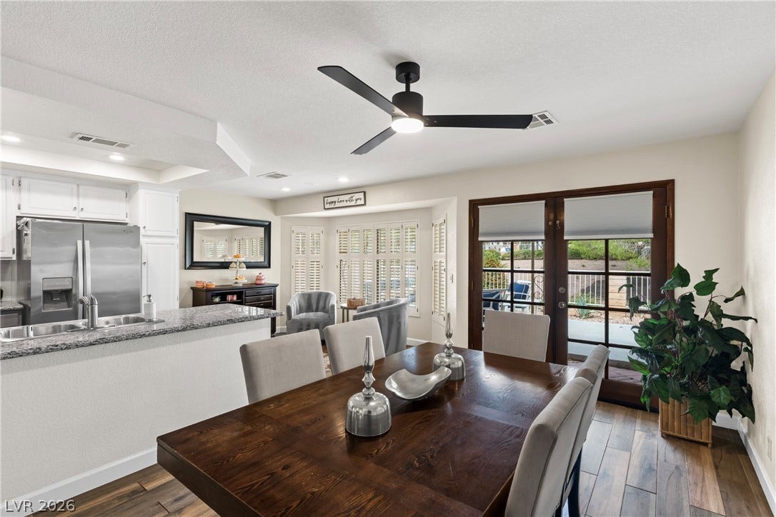 Rich wood-look flooring and glass doors to the patio anchor this welcoming dining area.