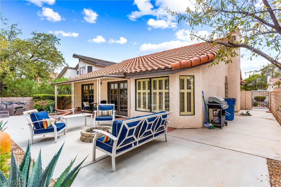 Spanish tile roofing and textured stucco walls frame this inviting outdoor patio space.