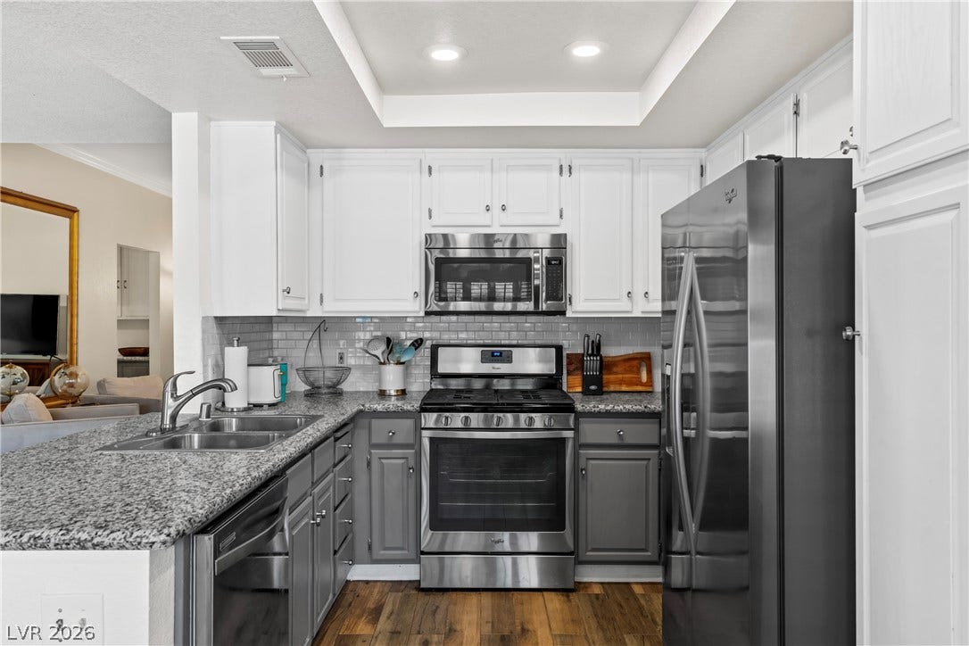 Rich wood-look flooring contrasts beautifully with classic granite countertops in this modern workspace.