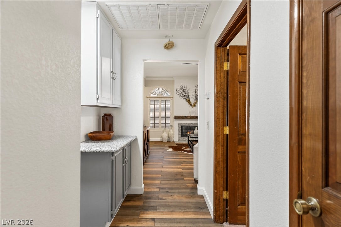 Rich wood-look flooring guides the eye through this functional hallway with built-in cabinetry.