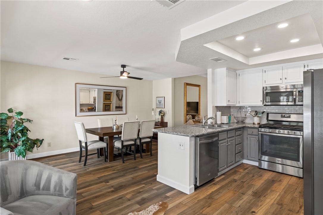 Rich wood floors seamlessly connect the open-concept kitchen and adjacent dining area.
