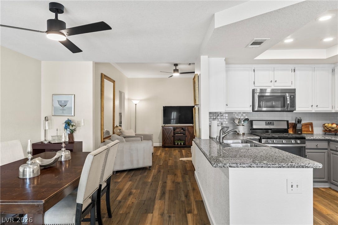 Rich wood floors seamlessly connect the dining space with an open-plan kitchen and living area.