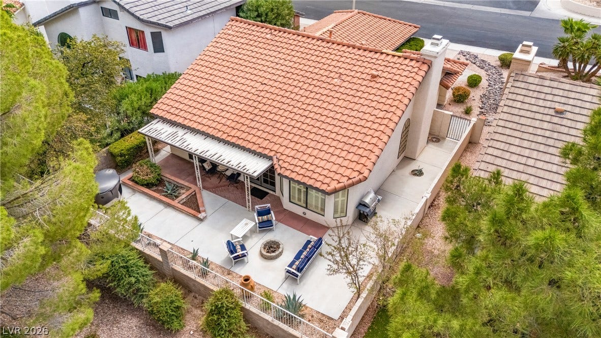 An aerial perspective reveals a barrel tile roof and a concrete patio with a built-in planter.