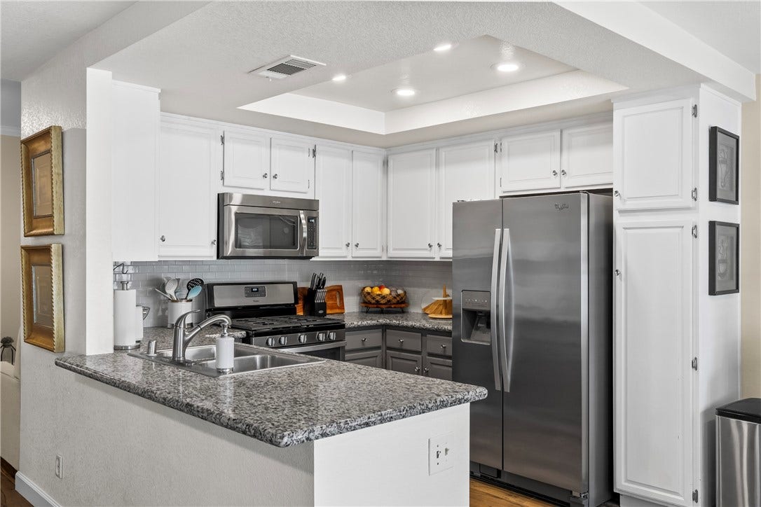 Polished stone countertops and seamless stainless steel appliances highlight this updated culinary space.