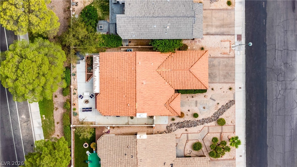An aerial perspective shows the orange tiled roof, private courtyard patio, and surrounding neighborhood streets.