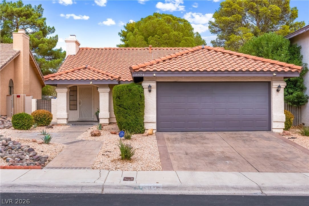 Classic Spanish tile roofing and desert-friendly landscaping frame this charming single-story home.