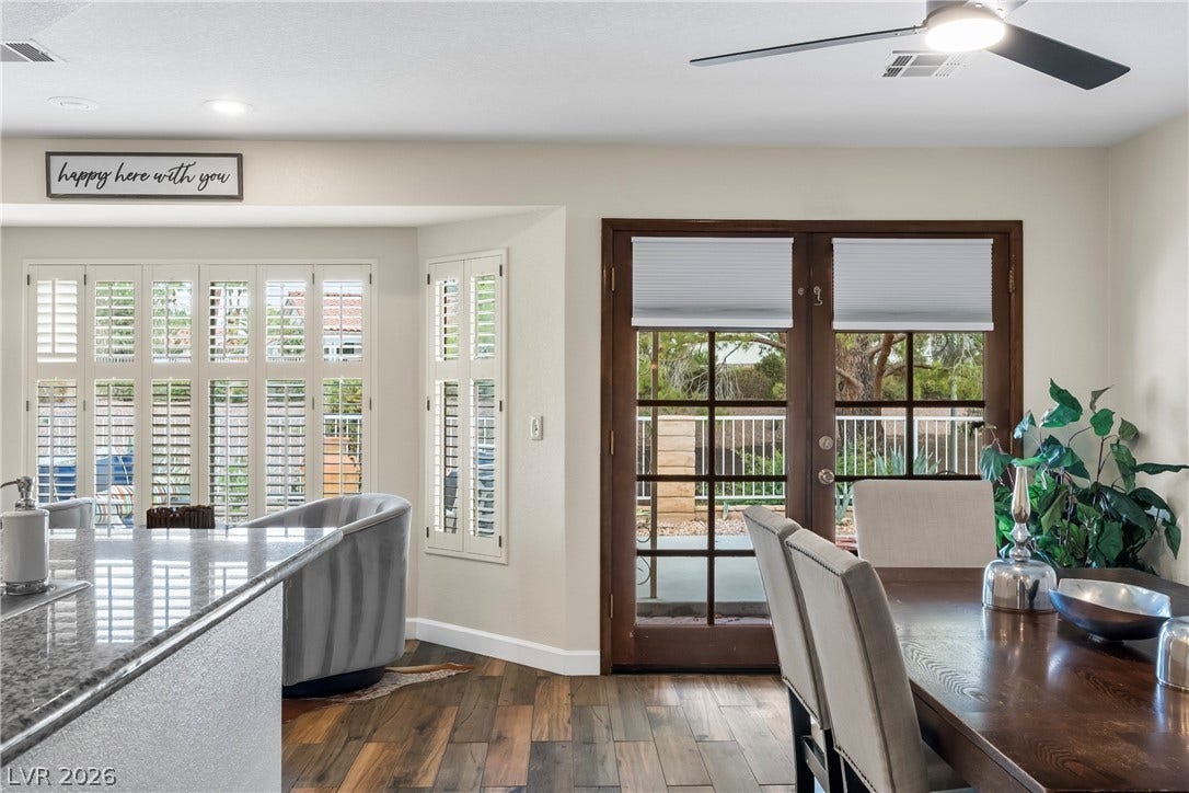 Rich wood flooring runs through this dining area boasting multi-pane glass doors.
