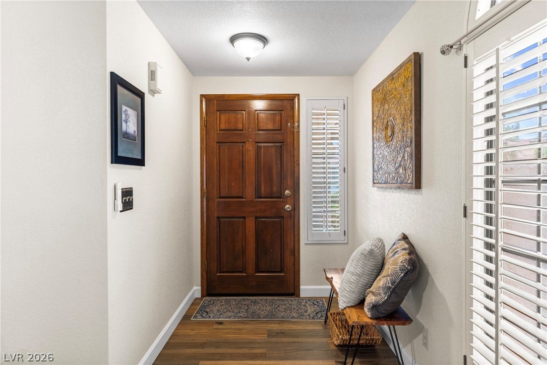 A classic wood door anchors this welcoming entryway featuring rich hardwood flooring.