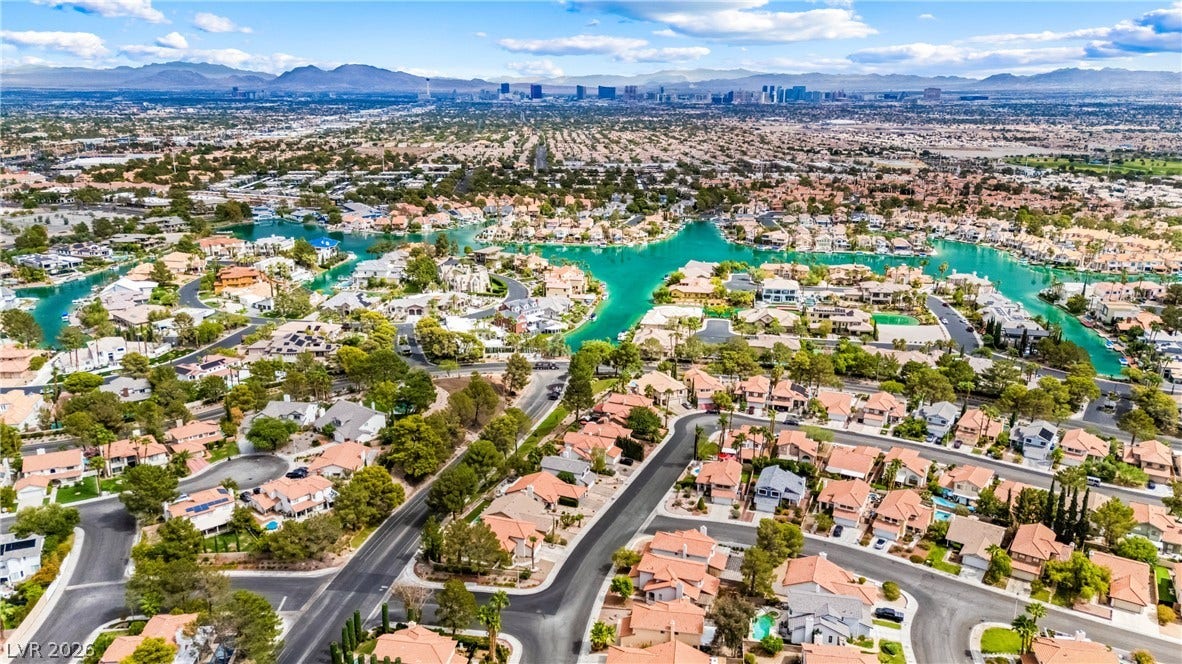 A sweeping bird's-eye perspective reveals winding residential streets set alongside calm, azure channels.