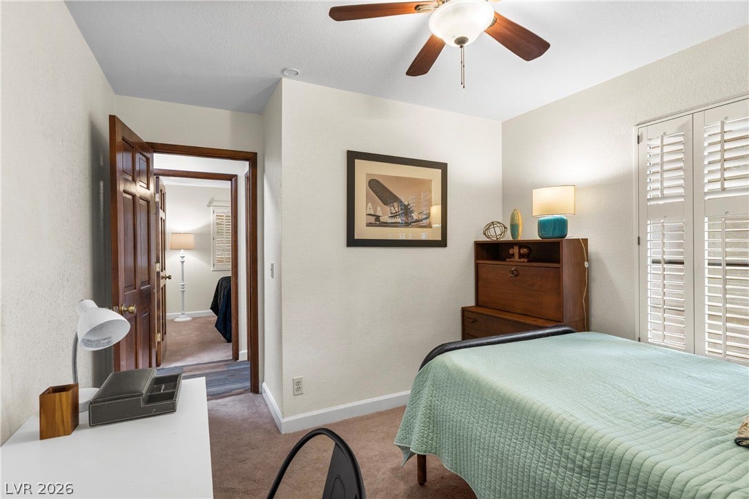 Rich wood doors and classic plantation shutters enhance this comfortable bedroom layout.