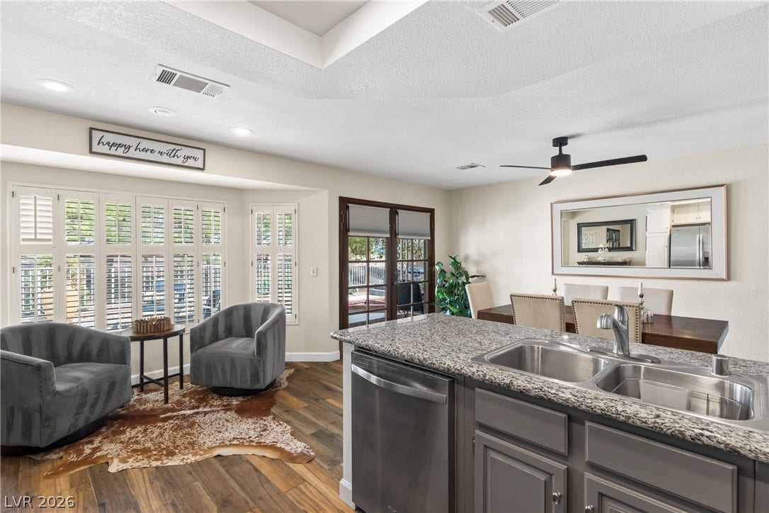 Polished stone counters and durable wood-look flooring enhance this inviting open layout.