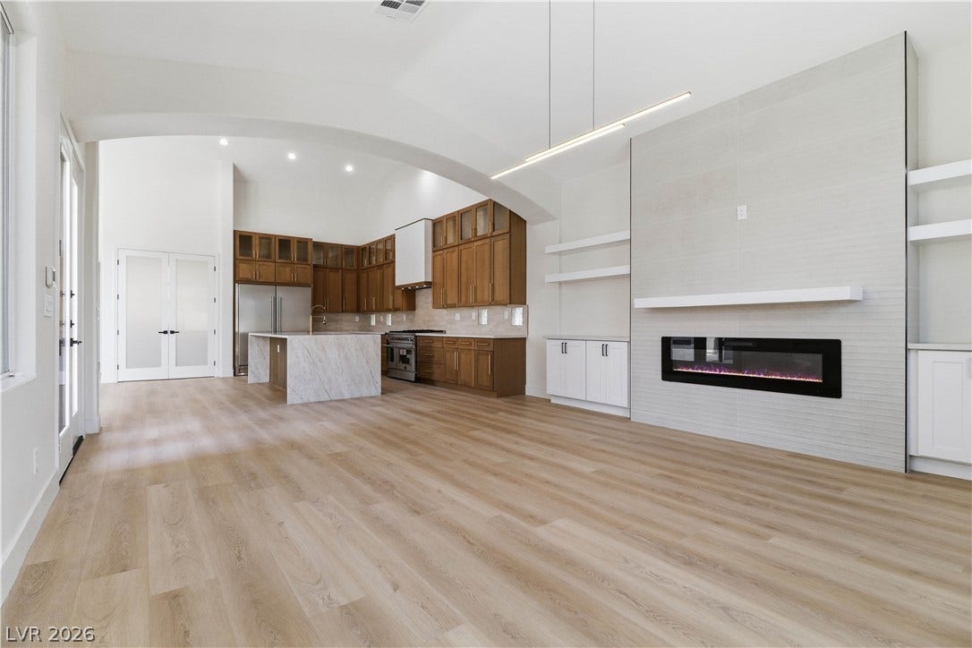 5150 Villa Dante Avenue, Las Vegas, NV 89141 Gleaming wood floors anchor a spacious living area featuring a modern linear fireplace.