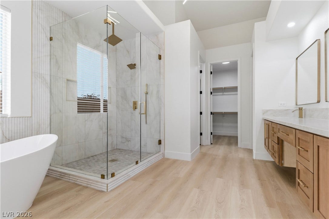 5150 Villa Dante Avenue, Las Vegas, NV 89141 A glass-enclosed walk-in shower and freestanding soaking tub highlight this modern primary bath.
