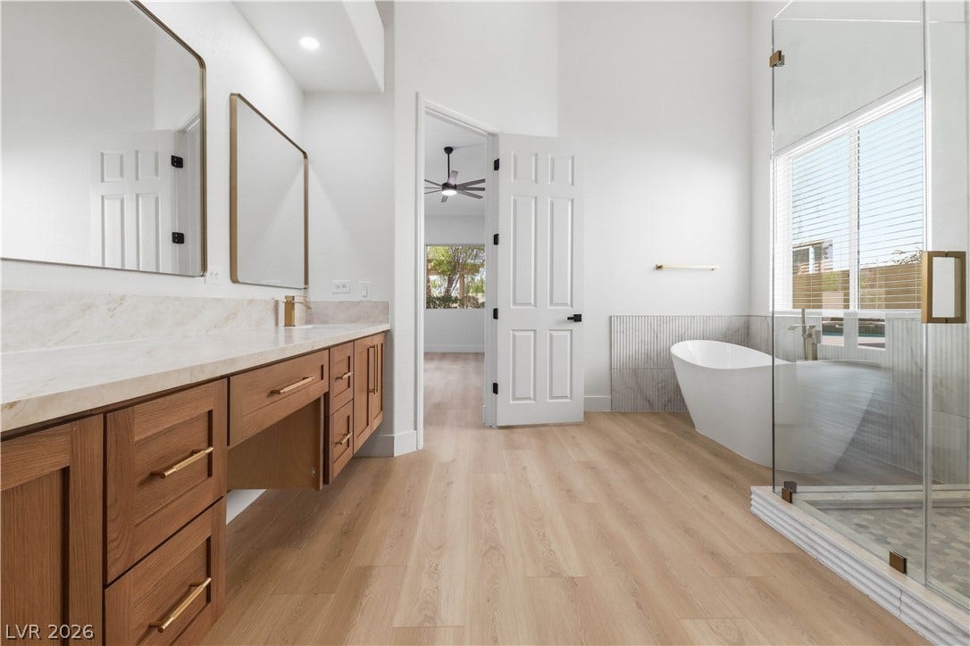 5150 Villa Dante Avenue, Las Vegas, NV 89141 High ceilings and warm wood floors elevate this master bathroom with its freestanding soaking tub.