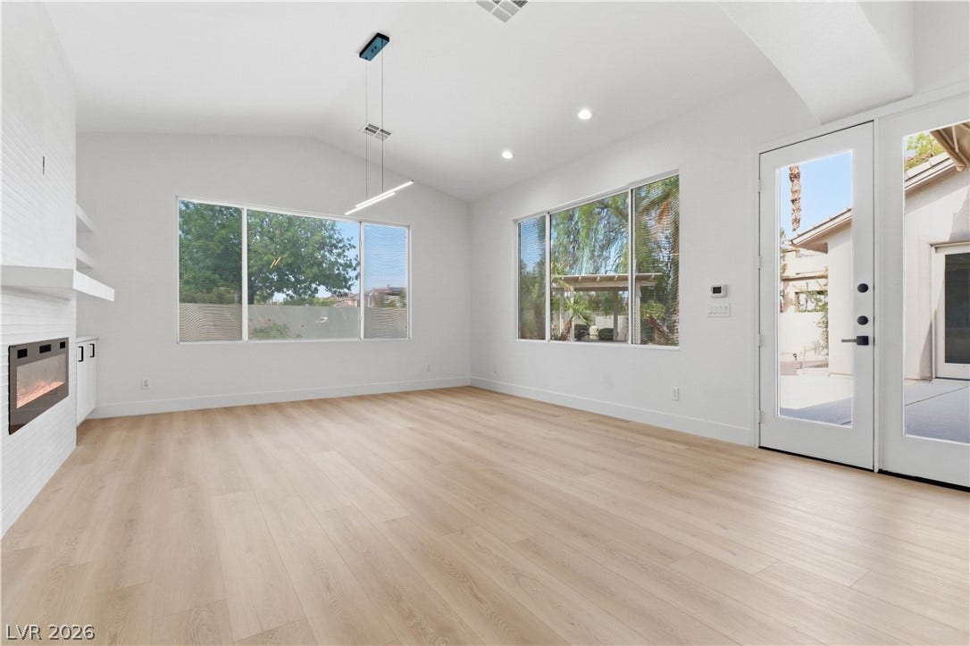 5150 Villa Dante Avenue, Las Vegas, NV 89141 Crisp white walls, vaulted ceilings, and light hardwood flooring define this welcoming living space.