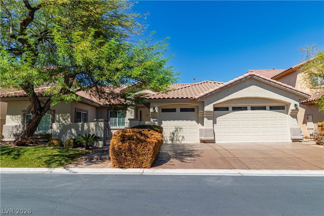 5150 Villa Dante Avenue, Las Vegas, NV 89141 Mature trees shade the front yard of this stucco home featuring a tiled roof.