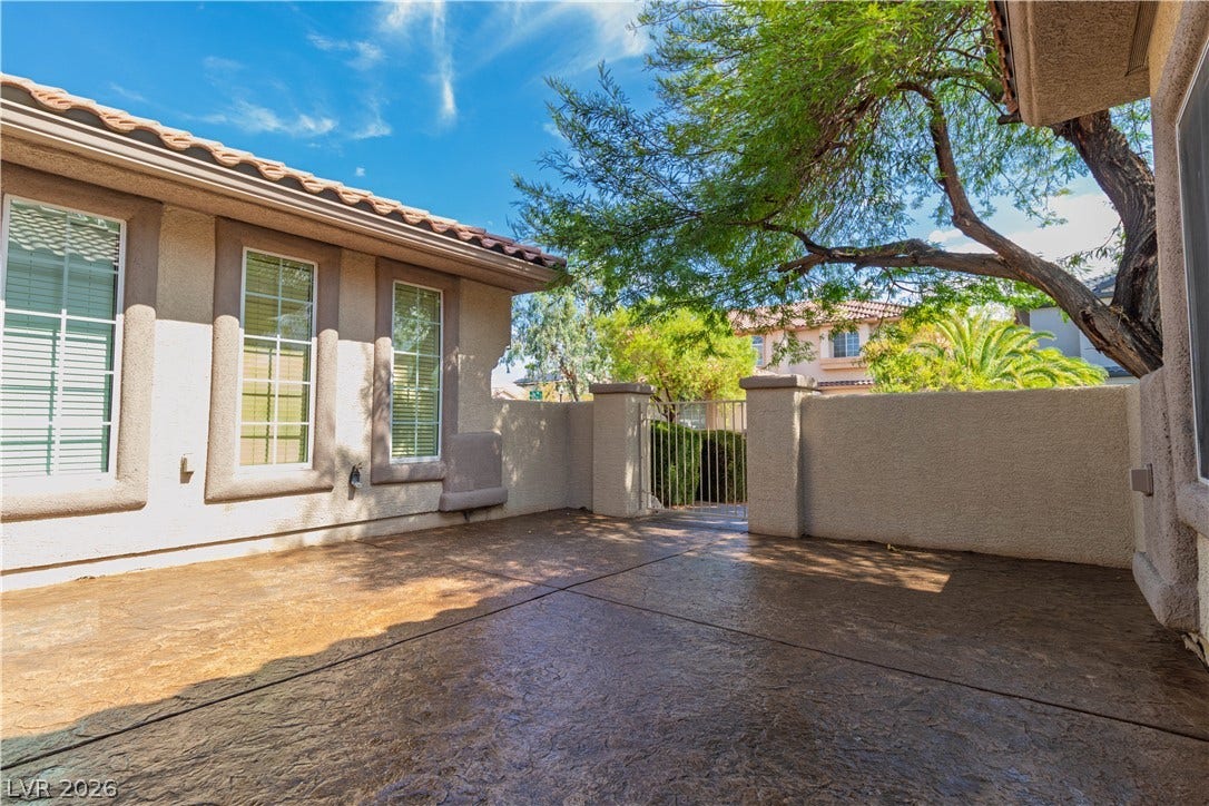 5150 Villa Dante Avenue, Las Vegas, NV 89141 An enclosed patio features textured concrete flooring and stucco walls beneath a tile roof.