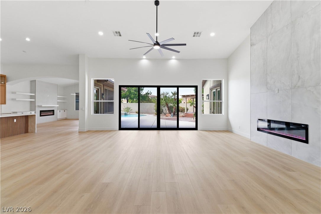 5150 Villa Dante Avenue, Las Vegas, NV 89141 Clean lines and smooth flooring define this light-filled room anchored by a modern fireplace wall.